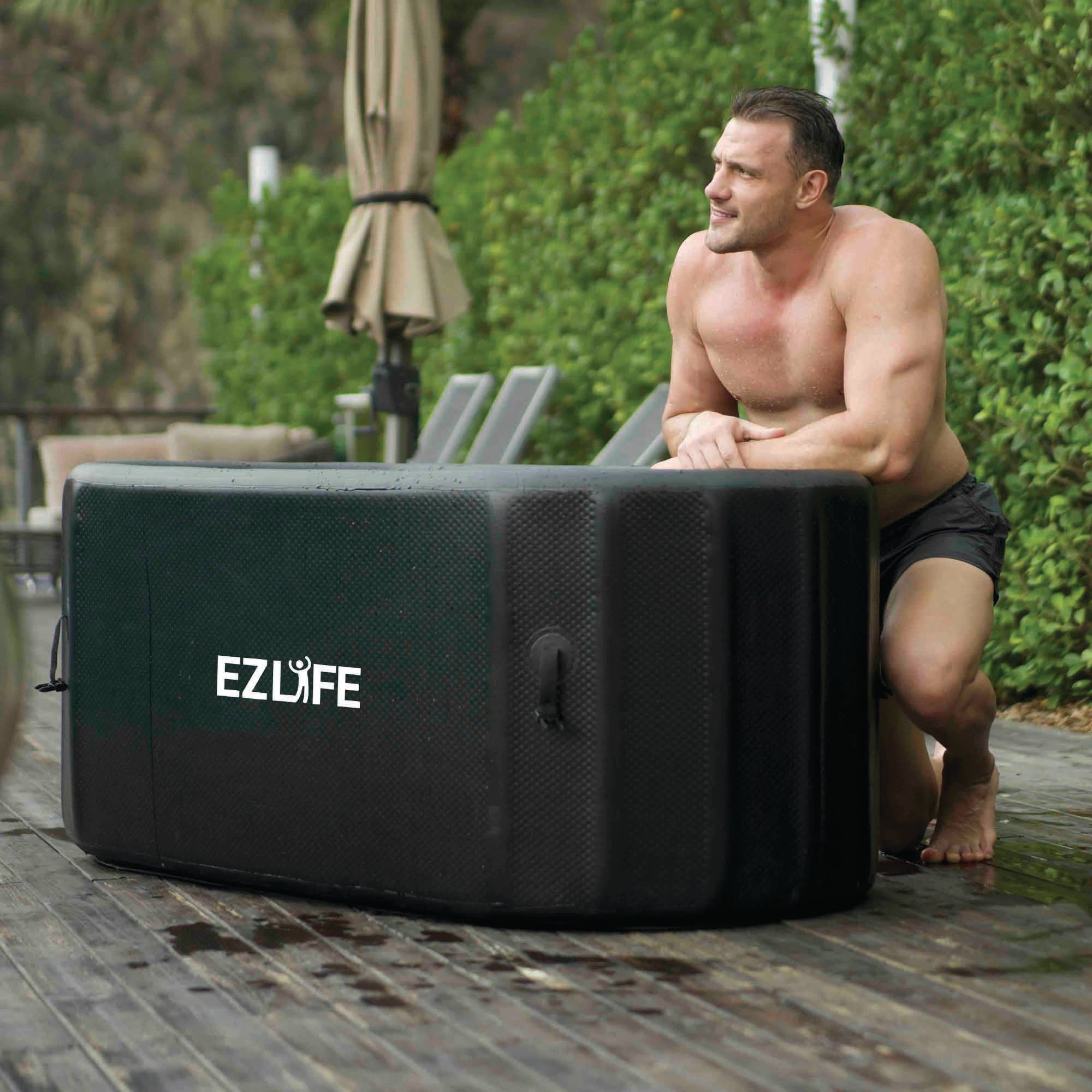 Man outdoors in swim trunks next to ice bath tub, "EZLIFE" logo on tub.